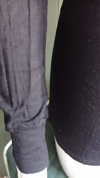 Jersey cuello alto negro con detalles dorados