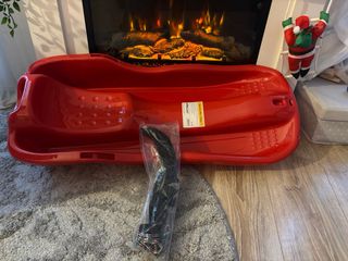 Trineo rojo con freno de mano, pago en mano.