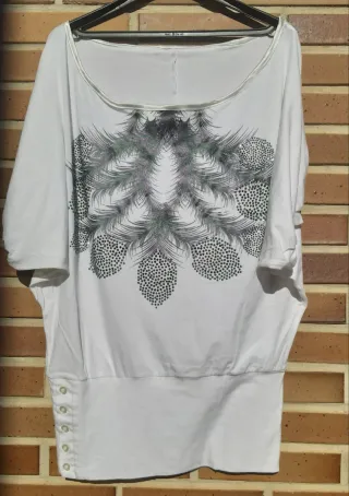 Camiseta blanca con pedrería morada y verde.