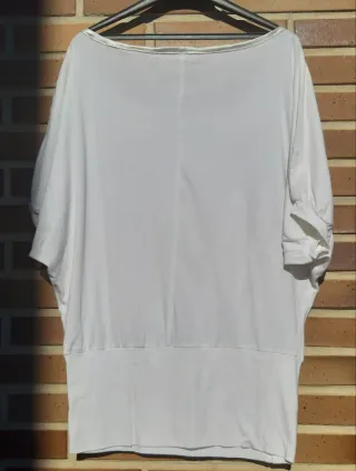 Camiseta blanca con pedrería morada y verde.