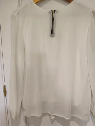 Blusa blanca de manga larga con plisados