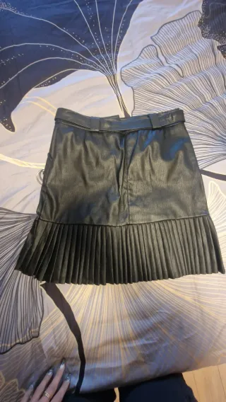 Falda mini polipiel con cinturón y plisado