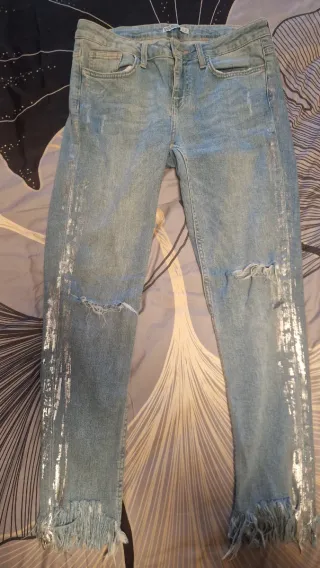 Jeans vaqueros desgastados con detalles plateados