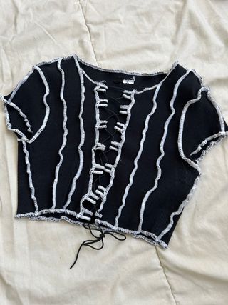 Top negro con cordones y costuras blancas