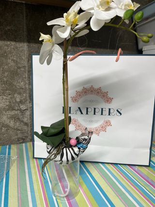 Jarrón de cebra con orquídea artificial