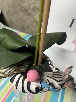 Jarrón de cebra con orquídea artificial