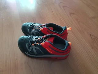 Zapatillas de montaña negras y naranjas.