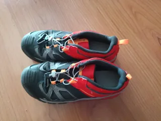 Zapatillas de montaña negras y naranjas.