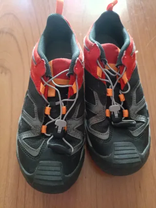 Zapatillas de montaña negras y naranjas.