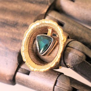 Anillo dorado ancho con piedra triangular verde