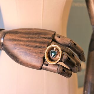 Anillo dorado ancho con piedra triangular verde