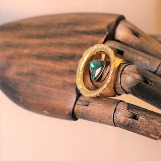 Anillo dorado ancho con piedra triangular verde