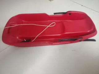 Trineo rojo para nieve de dos plazas.