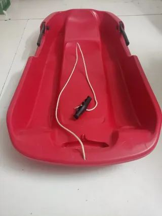 Trineo rojo para nieve de dos plazas.