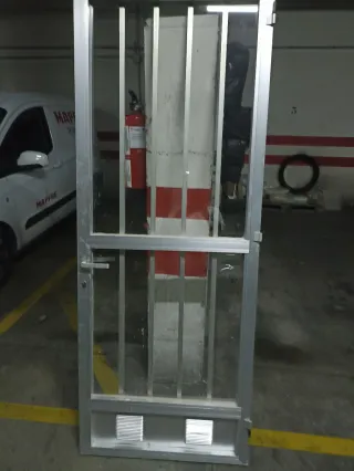 Puerta de aluminio con rejas y cristal