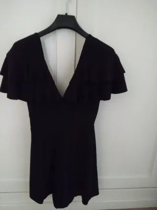 Mono corto negro con volantes y escote en pico.