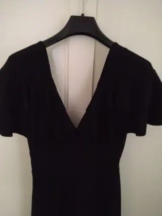 Mono corto negro con volantes y escote en pico.