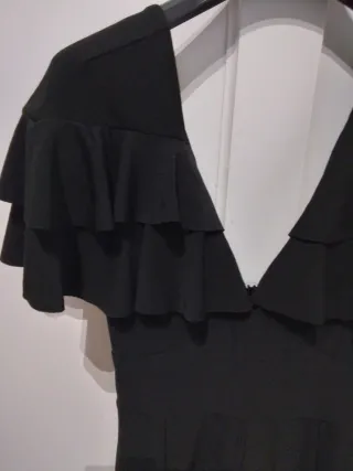 Mono corto negro con volantes y escote en pico.