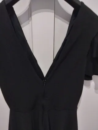 Mono corto negro con volantes y escote en pico.