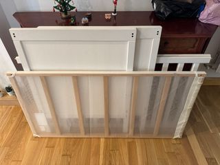 Cuna blanca, colchón y muchos accesorios de cama.