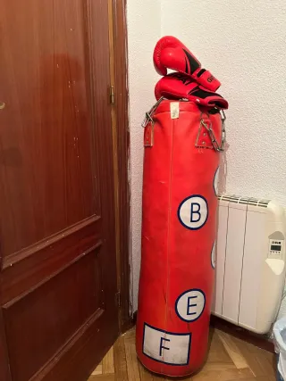 Saco de boxeo rojo con guantes