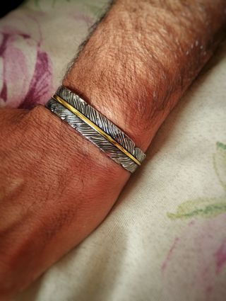Pulsera brazalete de pluma con línea dorada