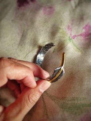 Pulsera brazalete de pluma con línea dorada