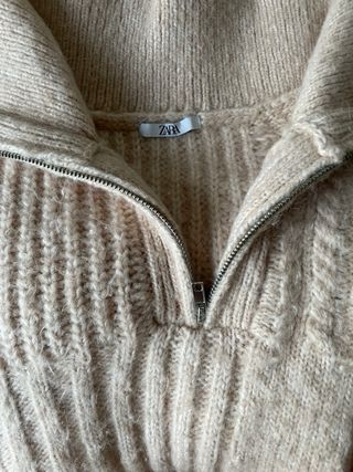 Jersey beige con cremallera y trenzas