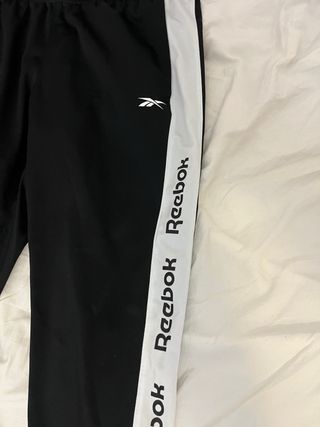 Pantalón largo deportivo Reebok negro y blanco.