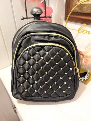 Mochila negra con tachuelas doradas