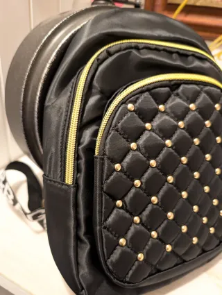 Mochila negra con tachuelas doradas