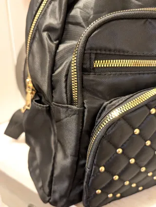Mochila negra con tachuelas doradas