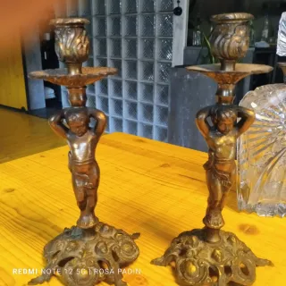 Antiguos candelabros de bronce con figuras