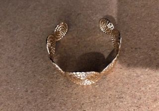 Brazalete dorado con diseño espiral