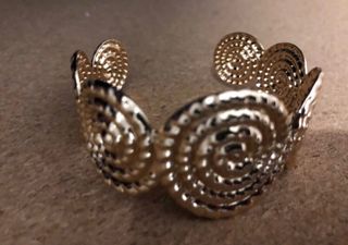 Brazalete dorado con diseño espiral