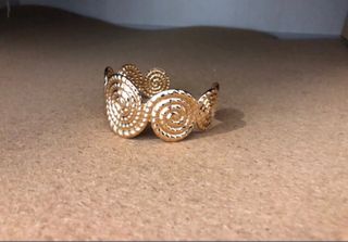 Brazalete dorado con diseño espiral