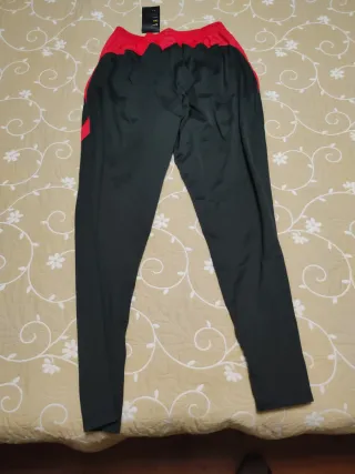 Pantalón chándal Nike negro y rojo.