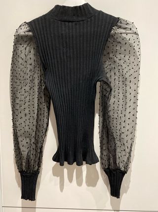 Blusa negra con mangas de tul.