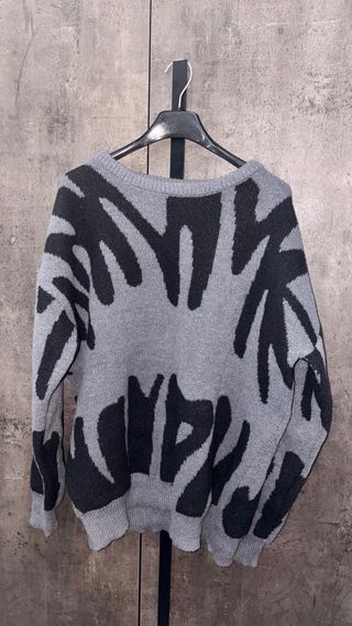 Maglione grigio e nero con stampa.