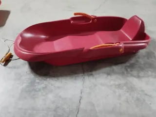 Trineo rojo con asas naranjas