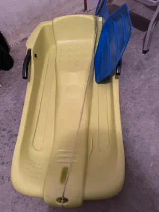 Trineo de plástico amarillo con pala azul
