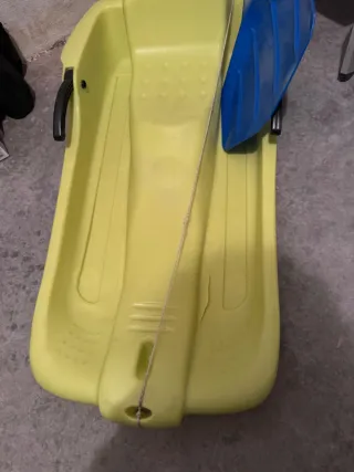 Trineo de plástico amarillo con pala azul