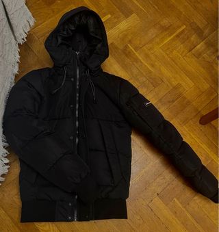 Abrigo acolchado negro con capucha de pelo