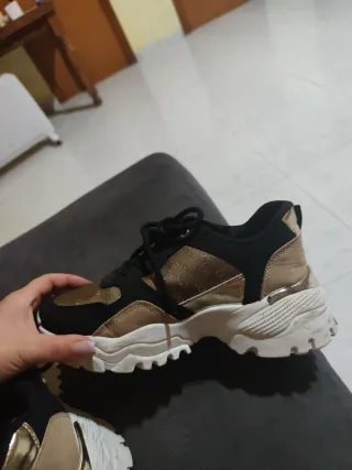 Zapatillas deportivas negras y doradas