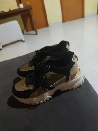 Zapatillas deportivas negras y doradas