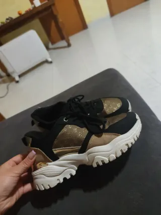 Zapatillas deportivas negras y doradas