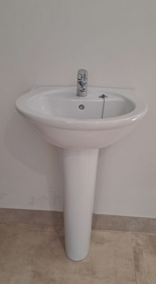 Lavabo de cerámica con pie y grifo