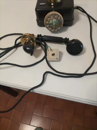 Teléfono antiguo de disco dorado y negro