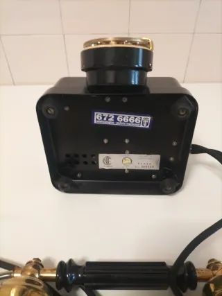 Teléfono antiguo de disco dorado y negro