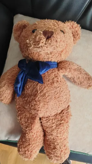 Oso de peluche marrón con lazo azul